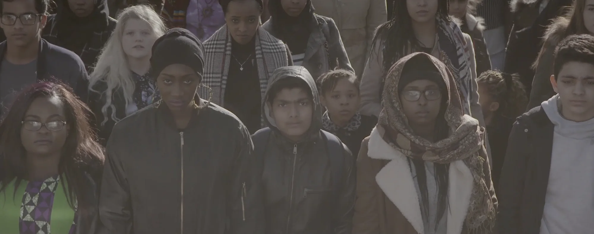A crowd of young people stands facing the camera